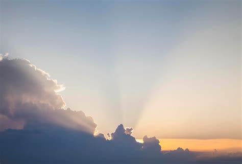 Los Rayos Dorados Del Sol Atraviesan Las Nubes Al Amanecer Foto Premium