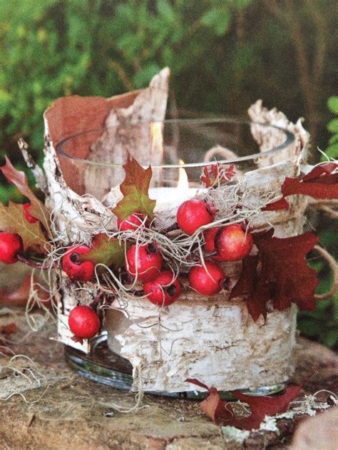 A Candle That Is Sitting On A Tree Stump With Berries And Leaves In The