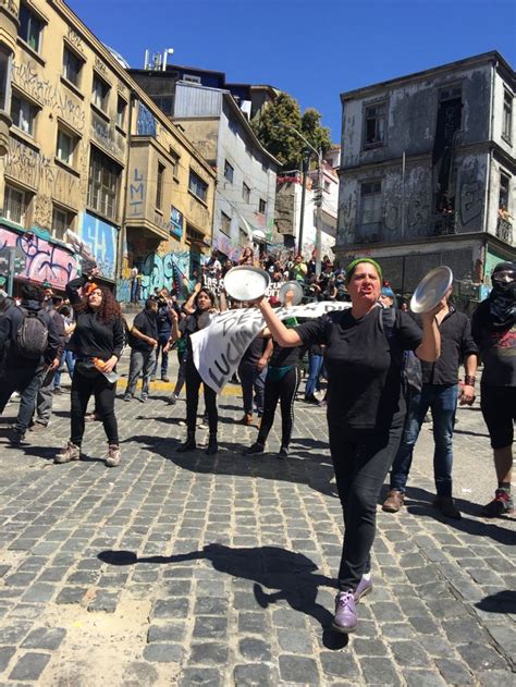 A Group Of People Playing With Frisbees In The Street