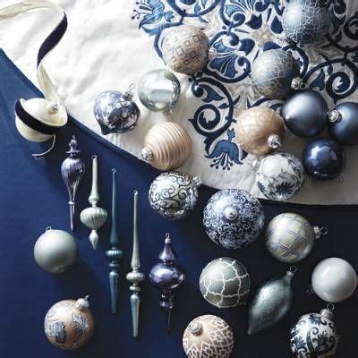 An Assortment Of Christmas Ornaments On A Blue And White Table Cloth