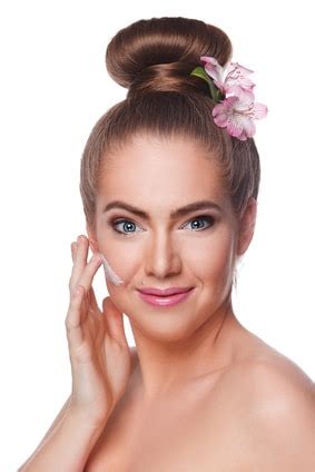 Beautiful woman putting face cream on Conseils santé