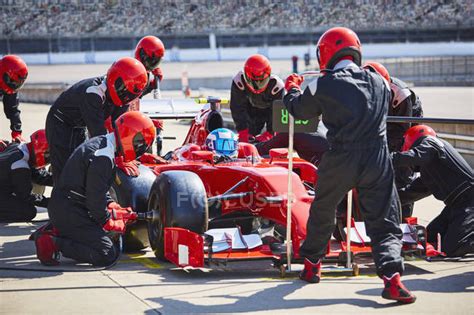 Pit crew working on formula one race car in pit lane — technical ...