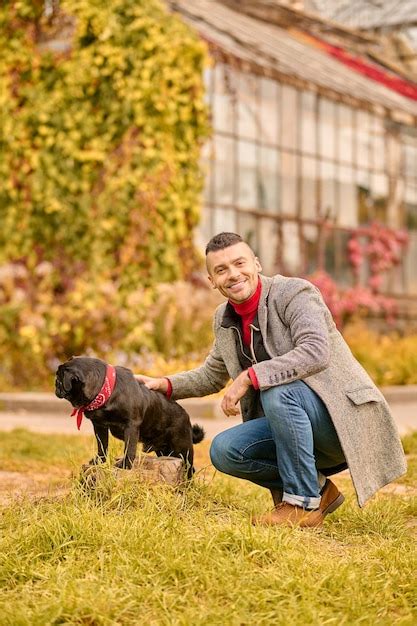 Free Photo A Man With A Black Dog In The Autumn Park