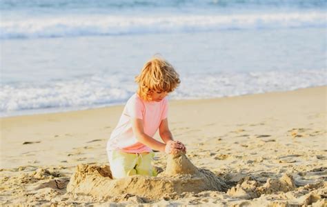 Menino brincando na praia nas férias de verão crianças construindo um