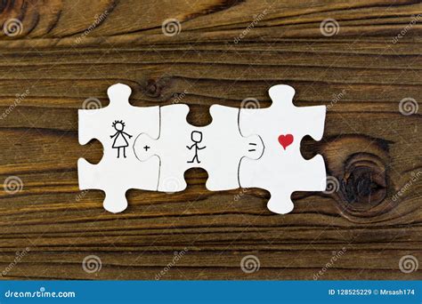 Puzzles With The Image Of A Couple Hearts On A Wooden Background