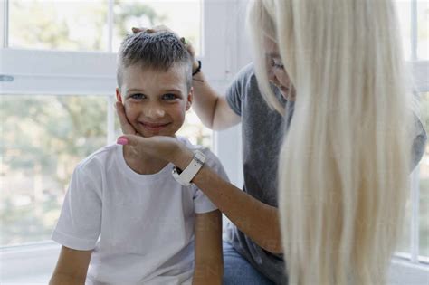 Liebevolle Blonde Mutter Sitzt Mit Ihrem Sohn Zu Hause Lizenzfreies Stockfoto