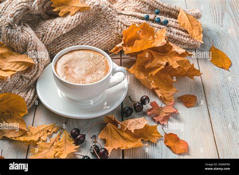 A cup of coffee on an autumn morning against the background of foliage ...