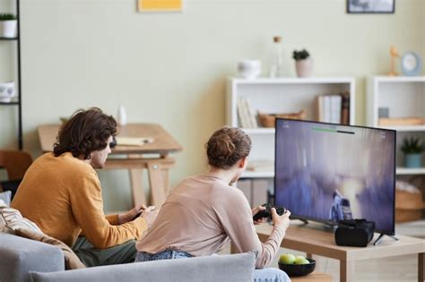 Premium Photo | Couple playing video games on tv at home