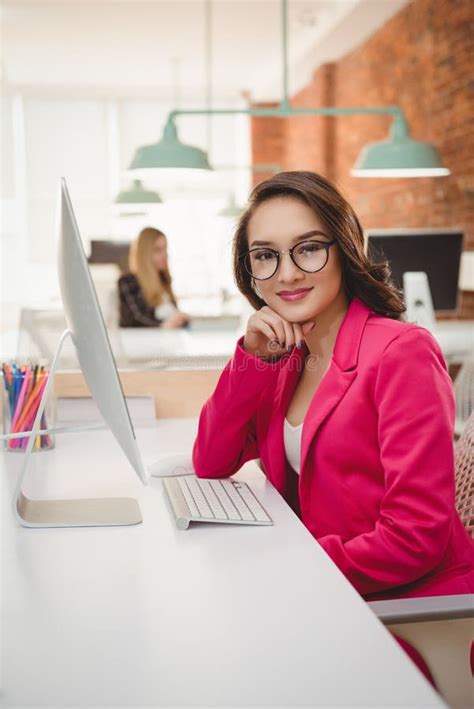 Portrait of Smiling Female Executive Sitting at Desk Stock Image ...