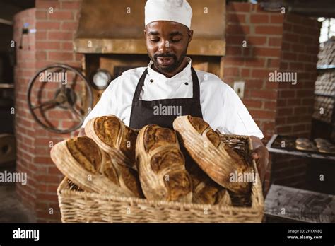 African American Mid Adult Male Baker Holding Breads In Wicker Basket