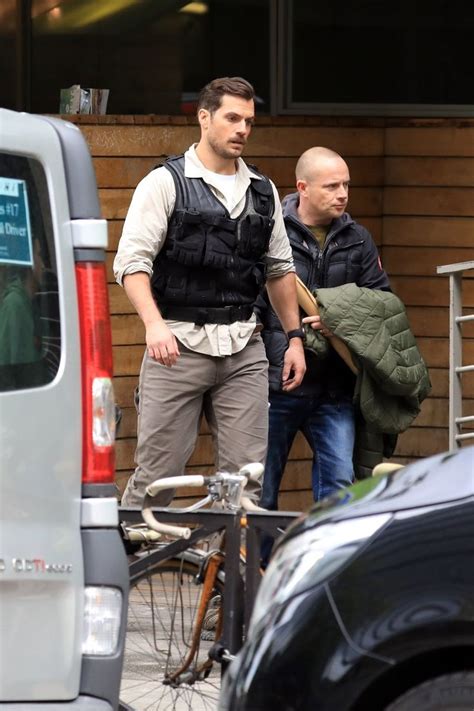 Two Men In Vests Are Standing Next To Bicycles