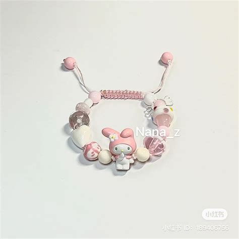 A Pink And White Bracelet With Charms On It