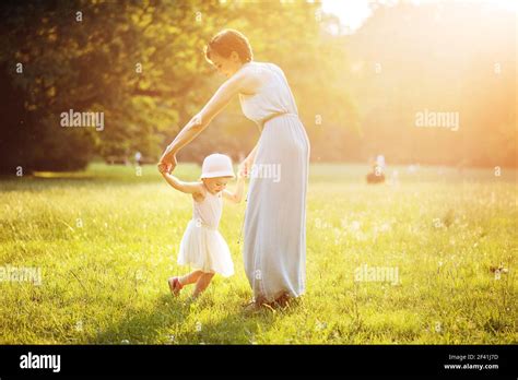 Attractive mother dancing with her daughter on the meadow Stock Photo ...