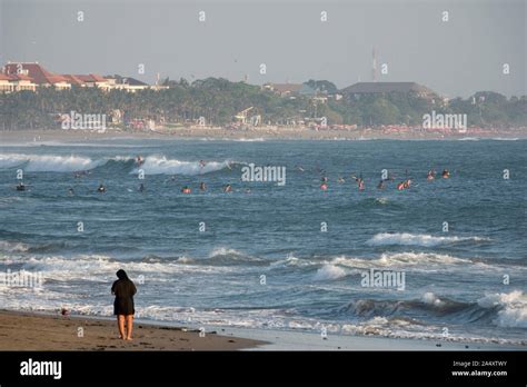 Surfers surfing waves at Seminyak in Bali Stock Photo - Alamy