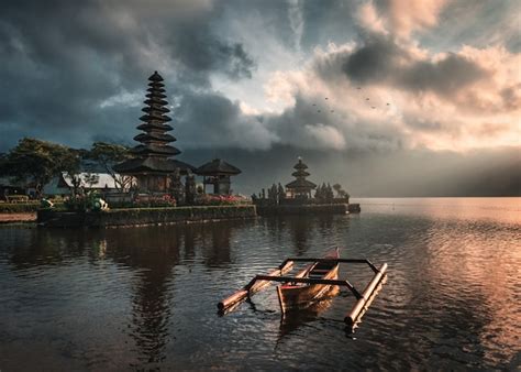 Premium Photo | Ancient temple of pura ulun danu bratan with traditional boat on bratan lake ...