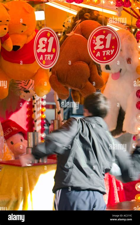 Man Trying To Knock Over A Stack Of Tins Fairground Sideshow Game Stock