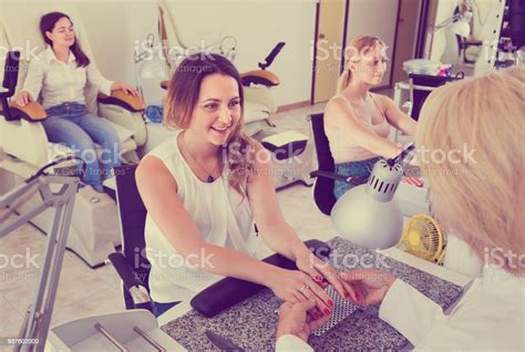 Two Women Clients Having Manicure Done In Nail Salon Stock Photo