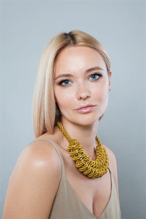 Cute Fashion Model Woman With Clear Fresh Perfect Skin And Long Blonde Hair Wearing Yellow