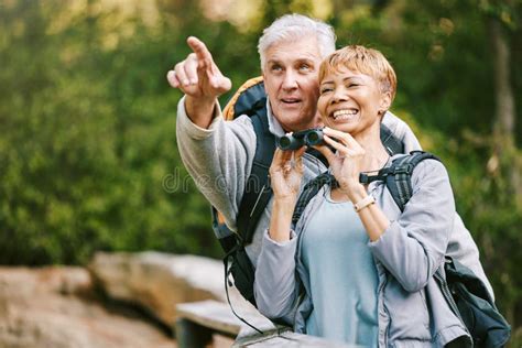 Elderly Couple Hiking And Bird Watching With Adventure Outdoor Hike