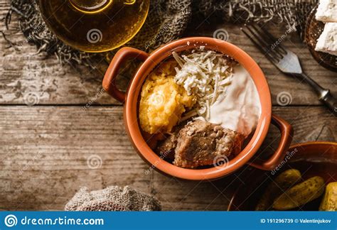 Delicious Polenta With Meat Cheese And Sour Cream In Bowl On Rustic