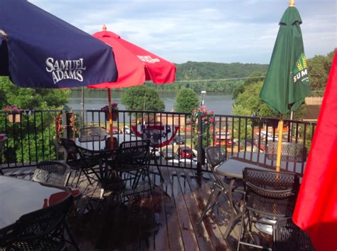 An Outdoor Patio With Tables And Umbrellas On The Deck Overlooking A