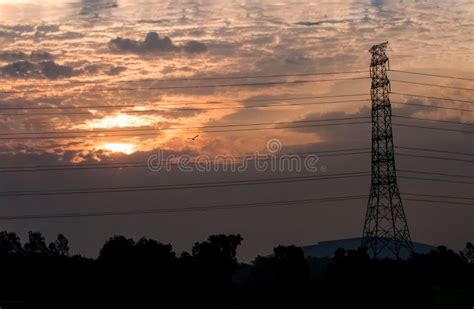 High Voltage Power Transmission Towers In Sunset Sky Background Stock