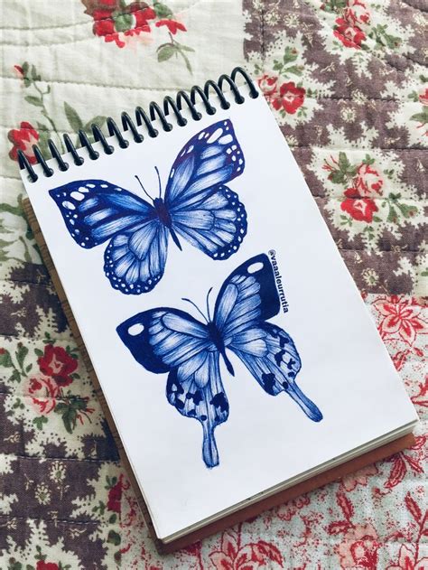 A Spiral Notebook With Two Blue Butterflies On It Sitting On Top Of A