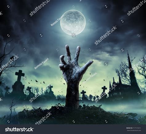 Стоковая фотография 717131011: Рука зомби поднимается из могилы ...