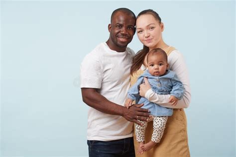 Retrato De La Familia Multirracial Feliz Contra Fondo Azul Claro Foto