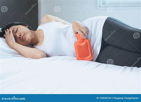 Asian Woman Hand Holding Hot Water Bag On Her Stomach Lying In Bedroom Stock Photo Image Of