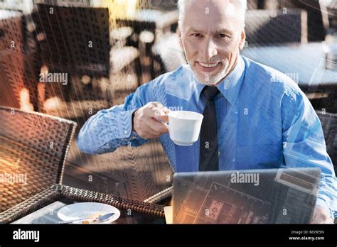 Mature Man Smiling And Drinking Coffee In A Nice Cafe Stock Photo Alamy
