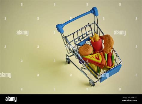 Closeup image of shopping cart full with junk foods like burger, fries ...