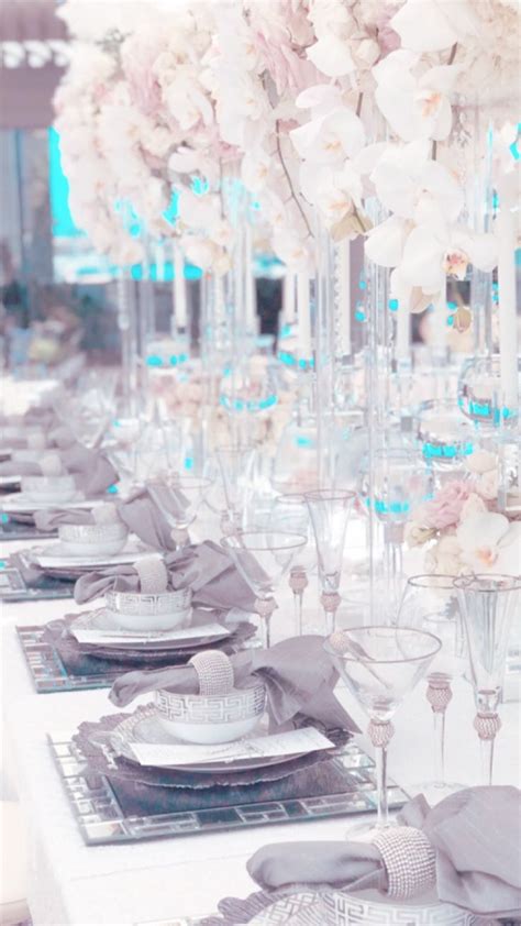 The Table Is Set With Silverware And White Flowers