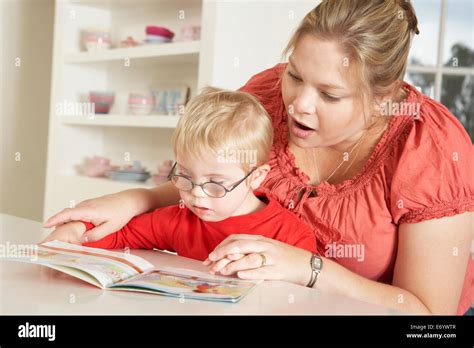 Mother And Downs Syndrome Son Reading Stock Photo Alamy