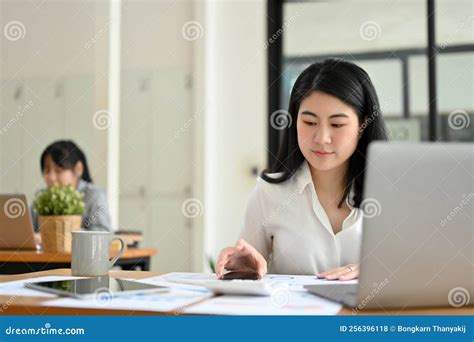 Asian Female Accountant Managing Her Financial Tasks And Working At Her