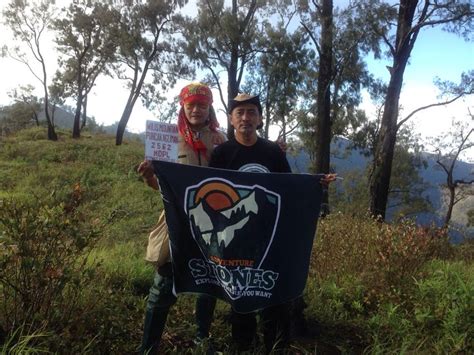 Two People Holding Up A Banner In The Woods