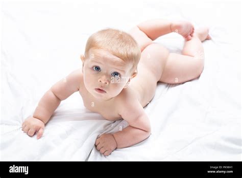 High Key Portrait Of An Adorable Naked Newborn Baby Lying On Its