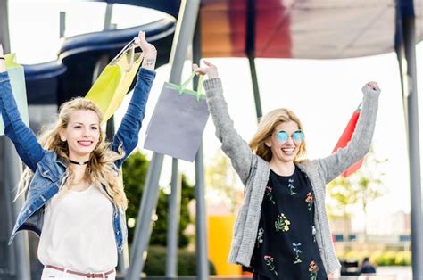 Dos Amigas De Compras Con Bolsas En El Centro Comercial Al Aire Libre