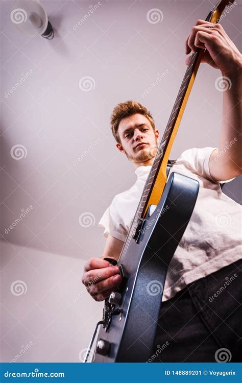 El Hombre Joven Est Tocando La Guitarra El Ctrica Imagen De Archivo