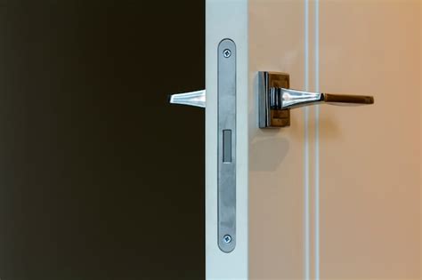 Premium Photo | Modern stainless steel door handle on white wooden doors