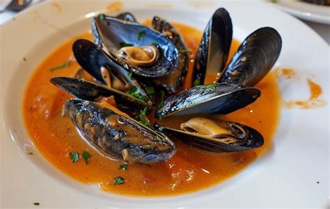 Premium Photo Delicious Mussels In Red Sauce With Liquid Metal Colors