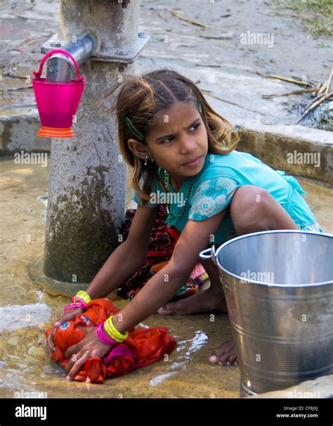 A Young Girl Washing Clothes At The Village Hand Pump Allahabad India