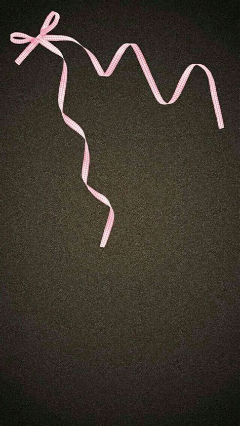 A Pink Ribbon With A Bow On It Is In Front Of A Black Background That