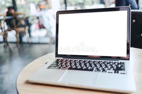 Laptop With Mock Up Blank Screen On Wooden Table In Front Of Cafe Space