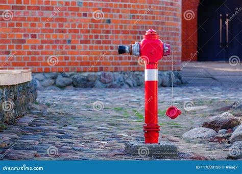 Red Fire Water Coming A Street Hydrant Near A Wall Stock Photo Image