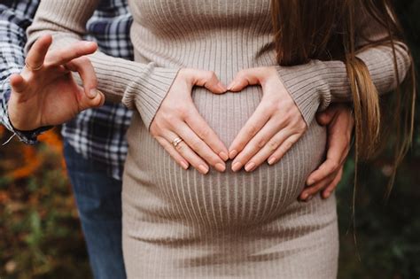 Premium Photo Heart Of Hands By Multiethnic Couple On Pregnant Belly