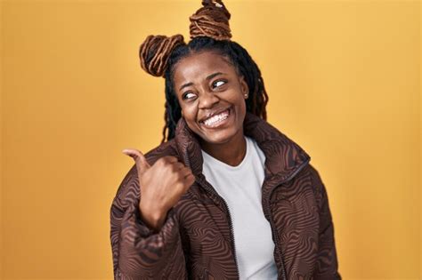 Mujer Africana Con El Pelo Trenzado De Pie Sobre Un Fondo Amarillo