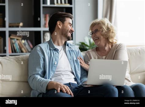 Happy Mature Woman Laughing At Photos On Computer With Son Stock Photo Alamy
