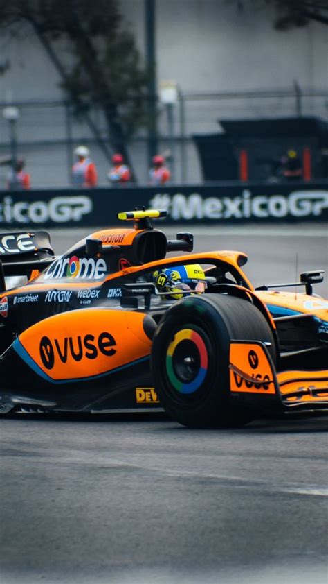 A Race Car Driving On A Track With Other Cars In The Background And One