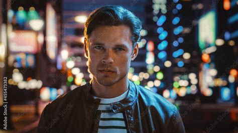 Portrait Of Handsome Serious Man Looking At Camera Standing In Night